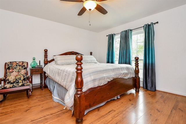 bedroom with a ceiling fan, light wood-style flooring, and baseboards