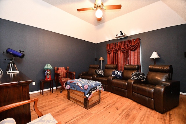 cinema with ceiling fan, baseboards, and wood finished floors