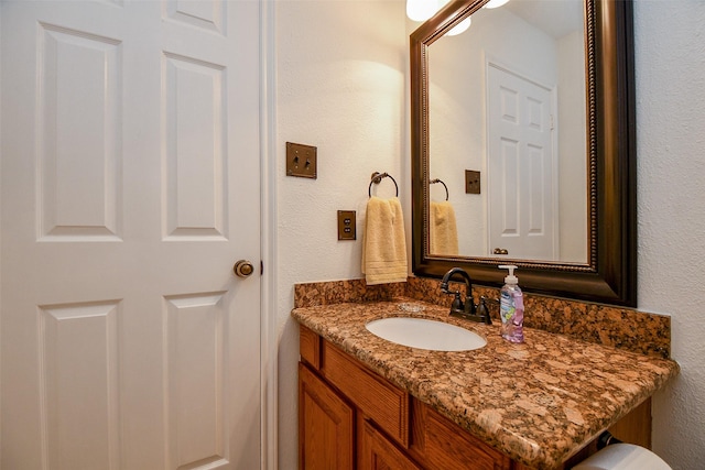 bathroom featuring a textured wall and vanity