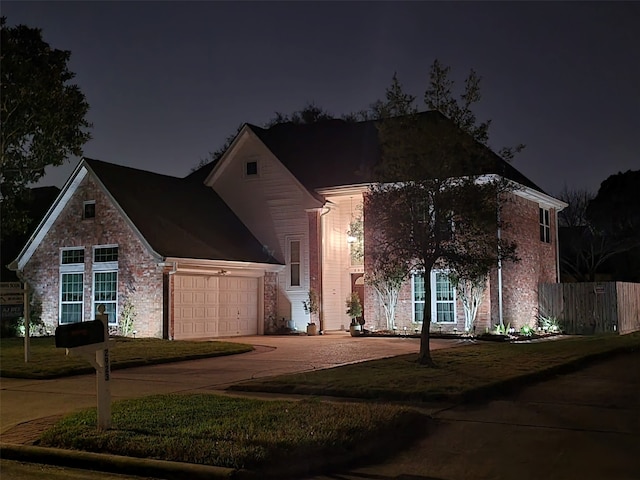 view of front of property featuring driveway, a yard, an attached garage, and fence