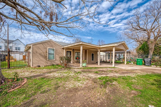 view of front of house with driveway, fence, a porch, and a carport