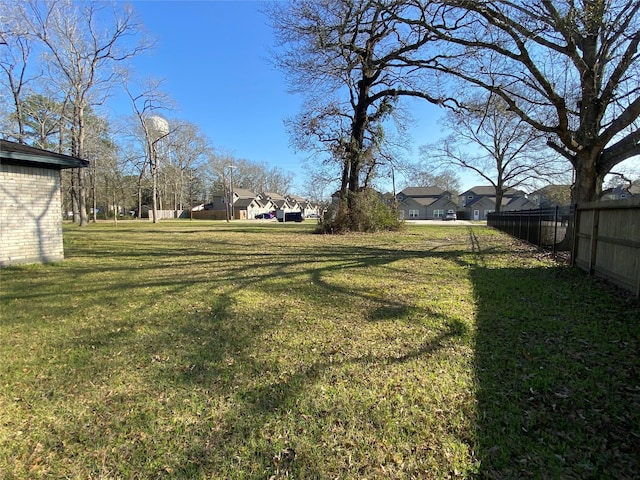 view of yard featuring fence and a residential view