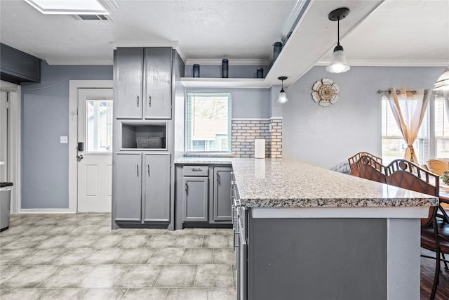 kitchen featuring ornamental molding, gray cabinets, a peninsula, and tasteful backsplash