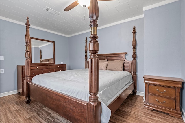 bedroom with ornamental molding, visible vents, and wood finished floors