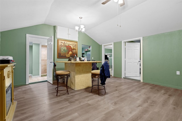 kitchen with light wood-type flooring, lofted ceiling, and a kitchen breakfast bar