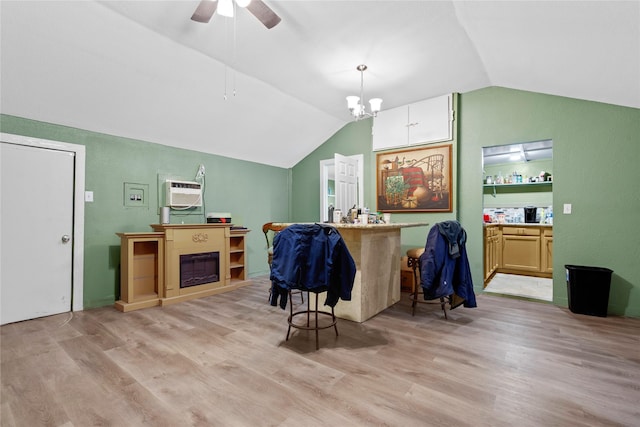 interior space with lofted ceiling, a wall mounted AC, ceiling fan with notable chandelier, and light wood-style flooring