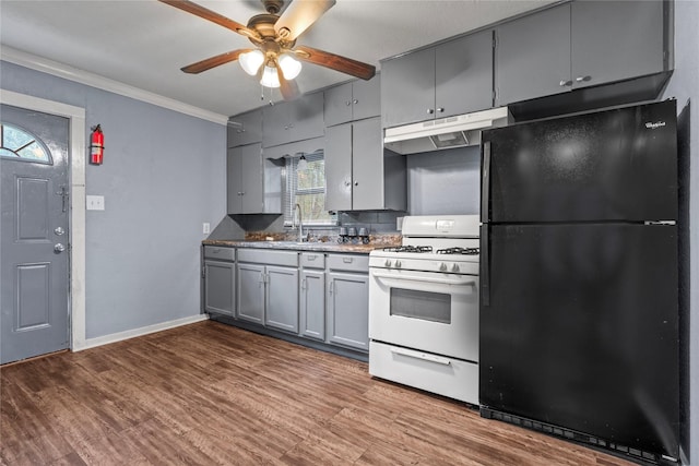 kitchen with white range with gas stovetop, ornamental molding, freestanding refrigerator, gray cabinets, and under cabinet range hood