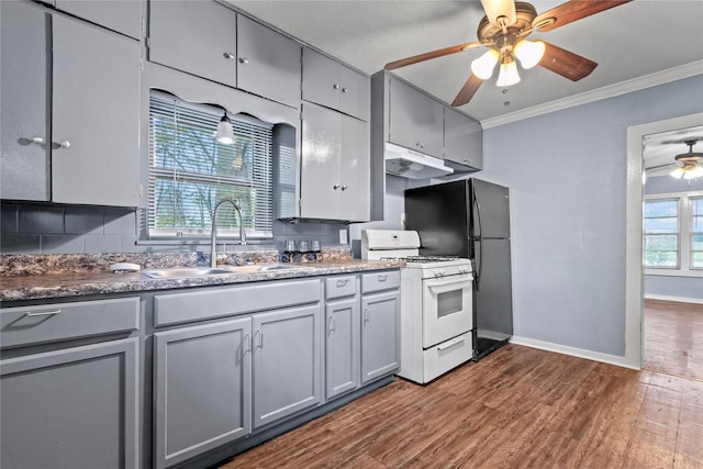 kitchen with ornamental molding, dark wood-style flooring, white gas range oven, and gray cabinetry