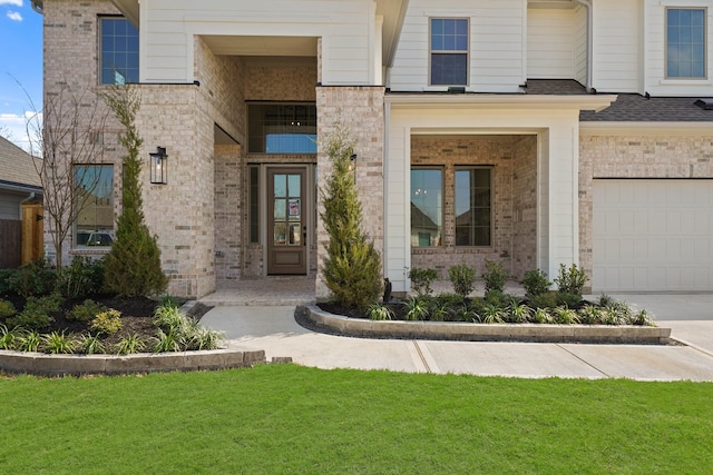 property entrance with a garage, brick siding, and a lawn