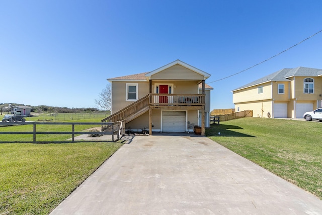 view of front of house featuring a garage, fence, concrete driveway, stairway, and a front yard