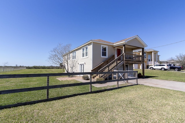 view of front of house with concrete driveway, a front lawn, and stairway