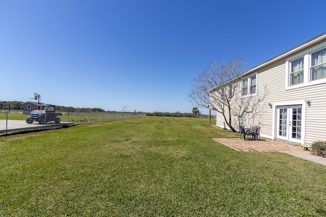 view of yard featuring french doors, fence, and a patio