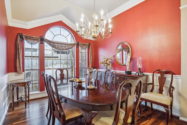 dining room featuring lofted ceiling, wainscoting, wood finished floors, and crown molding