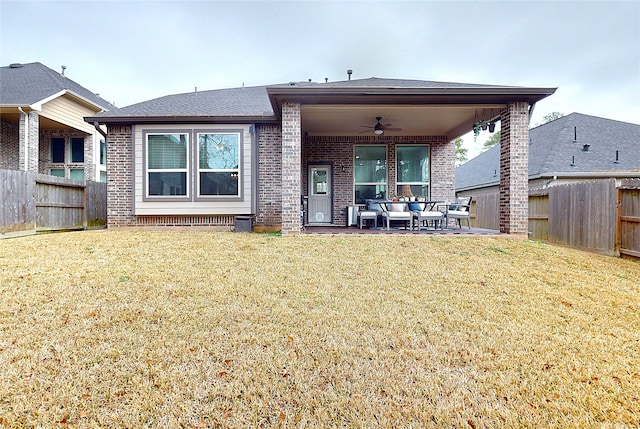 back of property featuring a yard, brick siding, a fenced backyard, and a ceiling fan