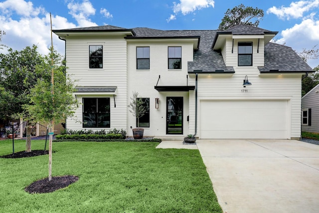 view of front facade featuring driveway, a front lawn, roof with shingles, and an attached garage