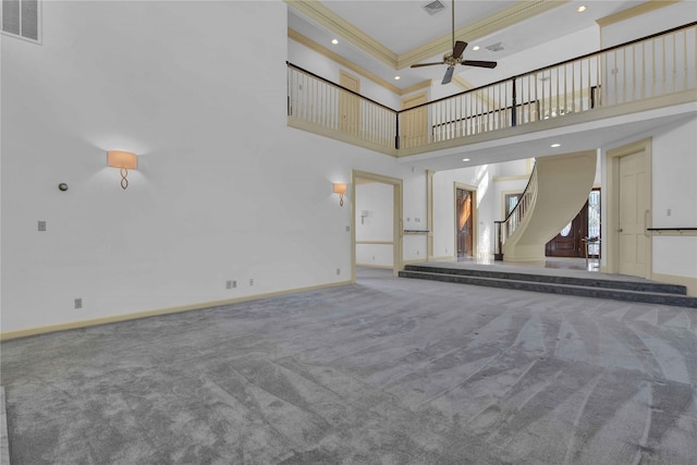 unfurnished living room featuring carpet floors, visible vents, stairway, ceiling fan, and baseboards