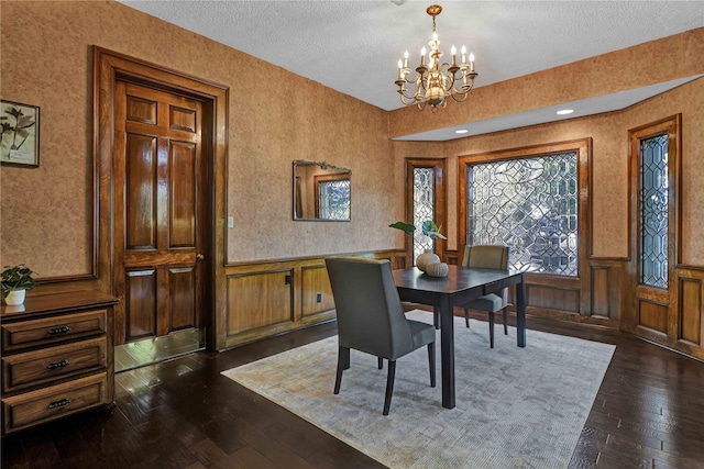 dining room featuring dark wood finished floors, a notable chandelier, and wainscoting