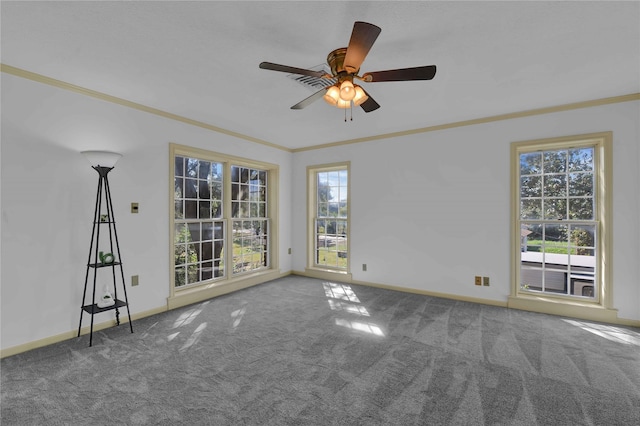 carpeted empty room with ornamental molding, a ceiling fan, and baseboards