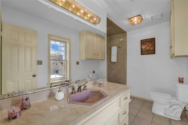 bathroom featuring baseboards, vanity, toilet, and tile patterned floors