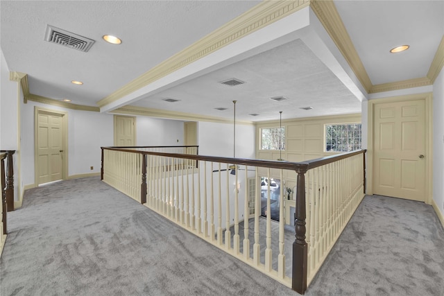 hall featuring carpet floors, visible vents, and ornamental molding