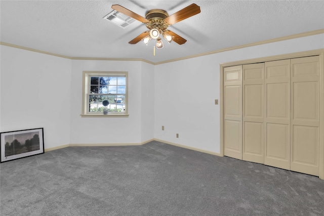 unfurnished bedroom featuring ornamental molding, carpet, and a textured ceiling