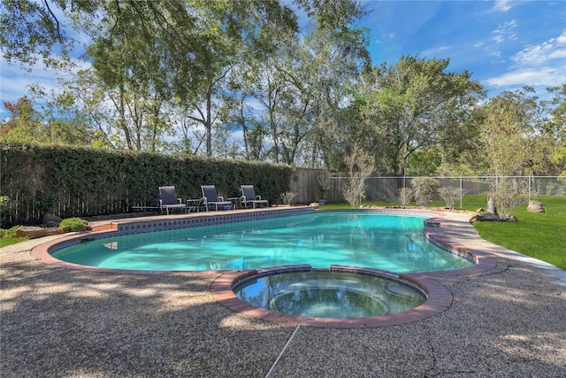 view of swimming pool with a fenced backyard and a pool with connected hot tub