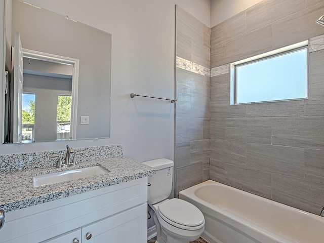 bathroom with a healthy amount of sunlight, toilet,  shower combination, and vanity