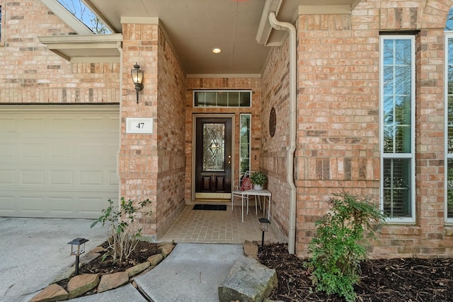 property entrance featuring a garage and brick siding