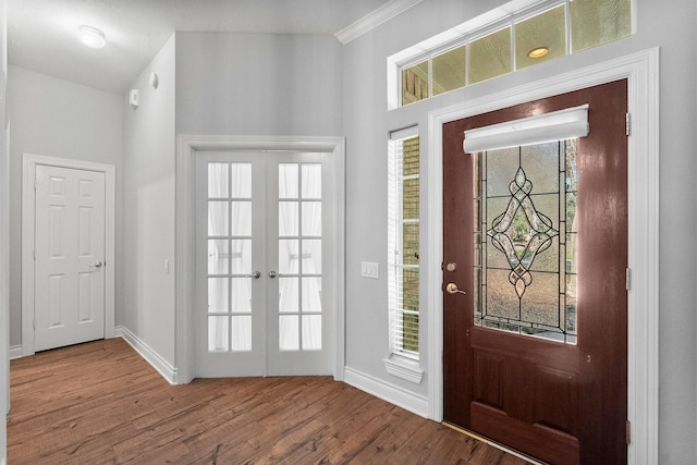 entryway featuring french doors, crown molding, baseboards, and wood finished floors