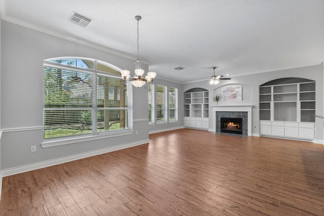 unfurnished living room with a tiled fireplace, wood finished floors, visible vents, and a healthy amount of sunlight