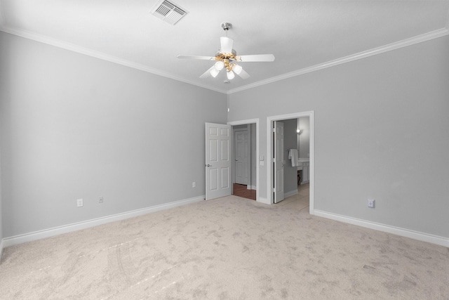 unfurnished bedroom featuring light colored carpet, visible vents, ensuite bathroom, ornamental molding, and baseboards