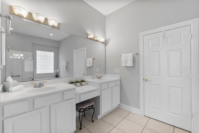 full bath with a stall shower, double vanity, a sink, and tile patterned floors