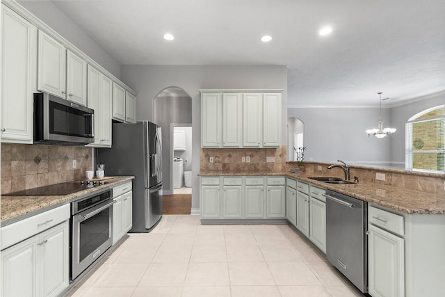 kitchen featuring appliances with stainless steel finishes, arched walkways, a sink, and light tile patterned floors