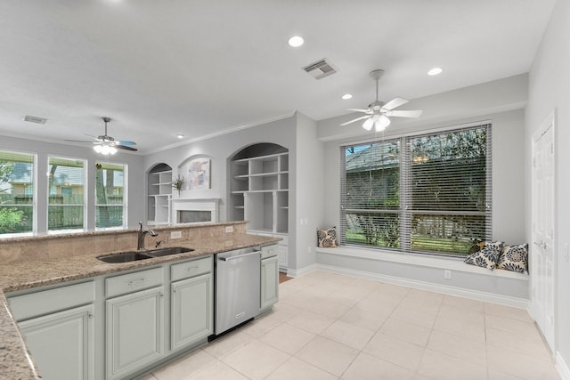 kitchen featuring baseboards, visible vents, built in features, stainless steel dishwasher, and a sink