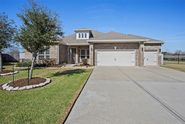 view of front of house featuring an attached garage, brick siding, fence, concrete driveway, and a front yard