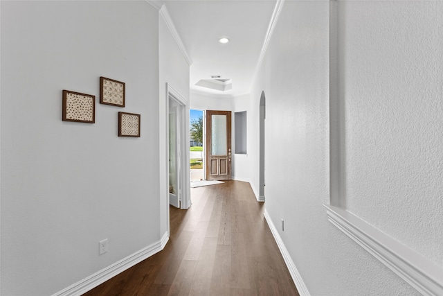 hallway featuring arched walkways, ornamental molding, dark wood-style flooring, and baseboards