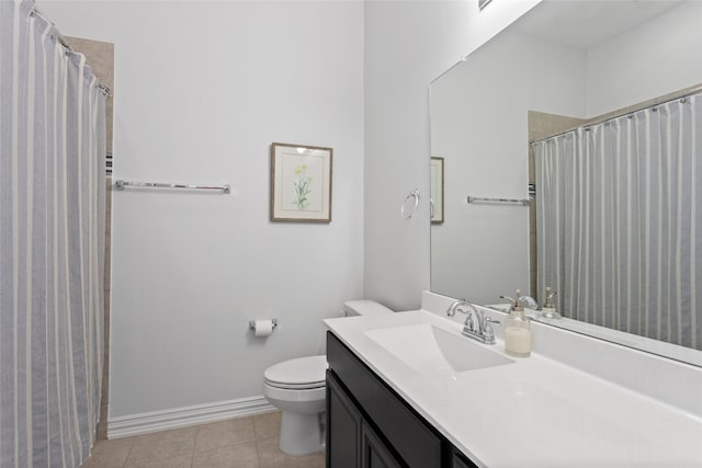 bathroom featuring baseboards, vanity, toilet, and tile patterned floors