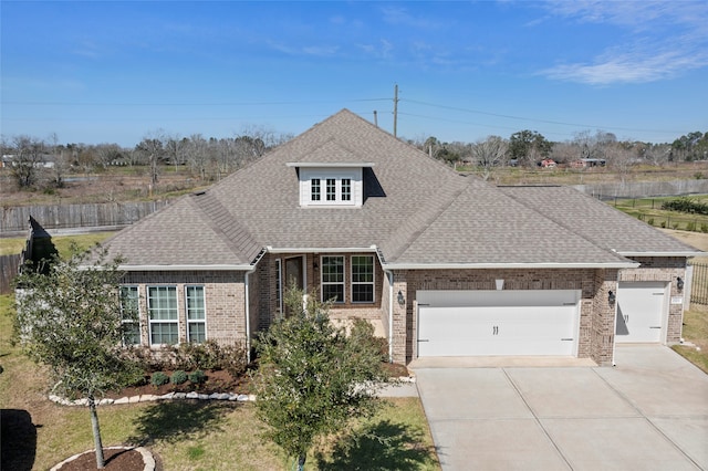 view of front of property with an attached garage, driveway, a shingled roof, and brick siding