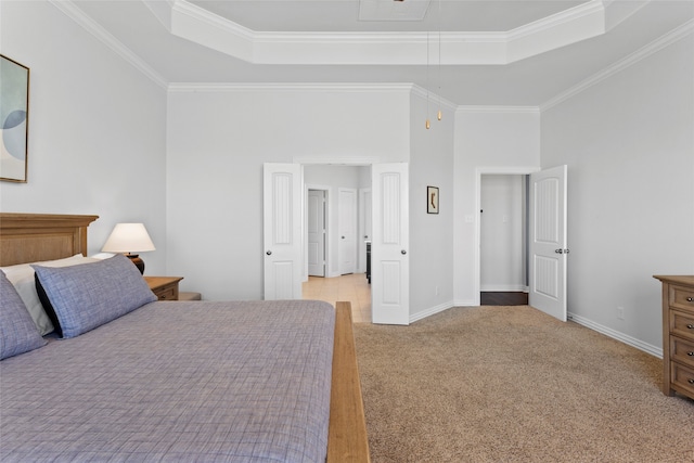 bedroom with attic access, a raised ceiling, light carpet, and ornamental molding