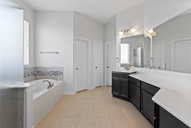 bathroom with vanity, a bath, and tile patterned floors