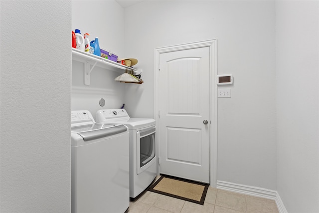 washroom featuring laundry area, independent washer and dryer, baseboards, and light tile patterned floors