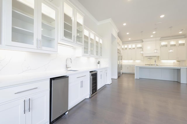 kitchen featuring refrigerator, beverage cooler, white cabinetry, and a sink