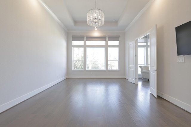 unfurnished room with baseboards, a tray ceiling, a chandelier, and dark wood-type flooring