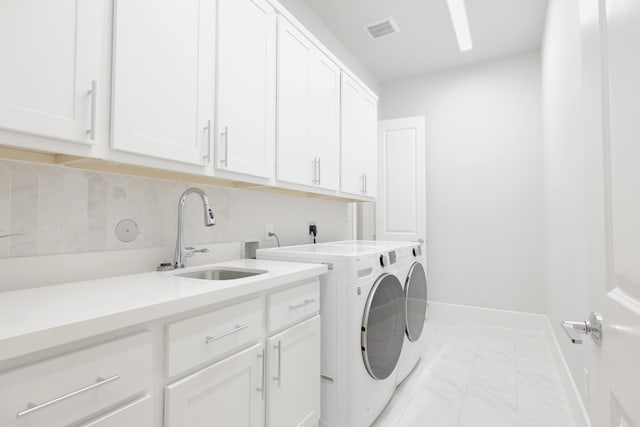 clothes washing area with marble finish floor, washer and clothes dryer, cabinet space, visible vents, and a sink