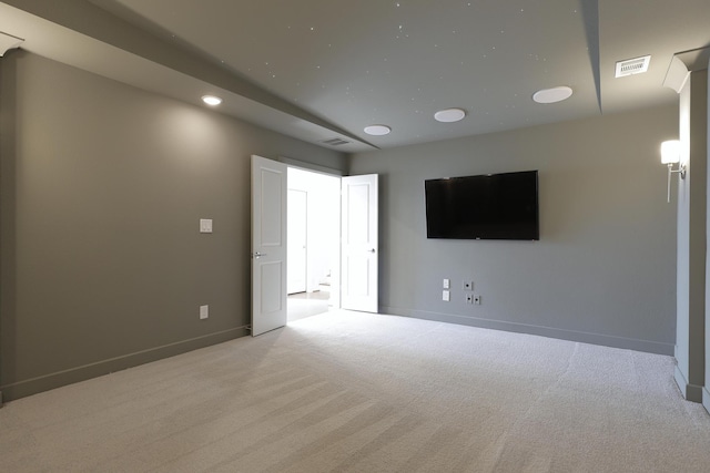 spare room featuring carpet, visible vents, and baseboards