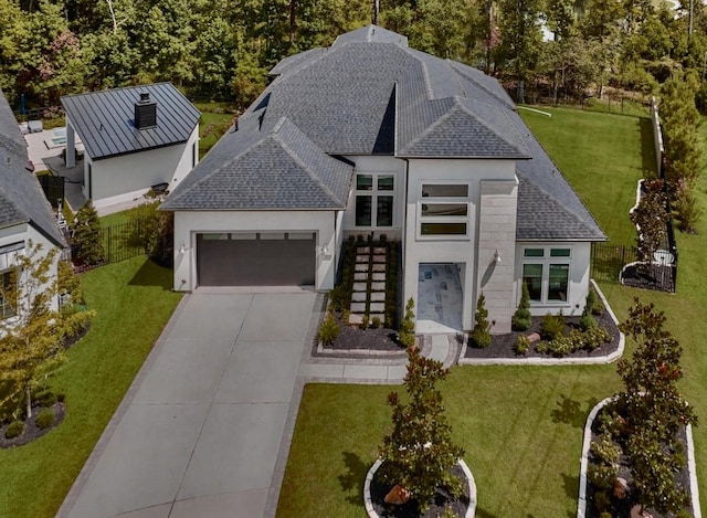 view of front of house with metal roof, a garage, concrete driveway, roof with shingles, and a standing seam roof