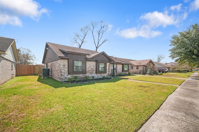 ranch-style home with brick siding, roof with shingles, fence, cooling unit, and a front yard