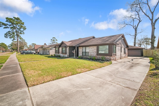 view of front of property featuring a front lawn, a detached garage, fence, and brick siding