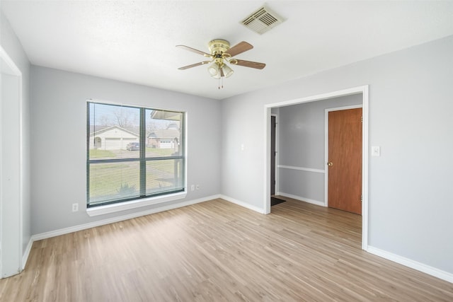 unfurnished room with light wood-style flooring, visible vents, ceiling fan, and baseboards