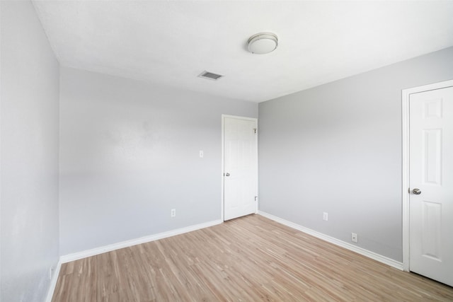 unfurnished room featuring light wood-type flooring, baseboards, and visible vents